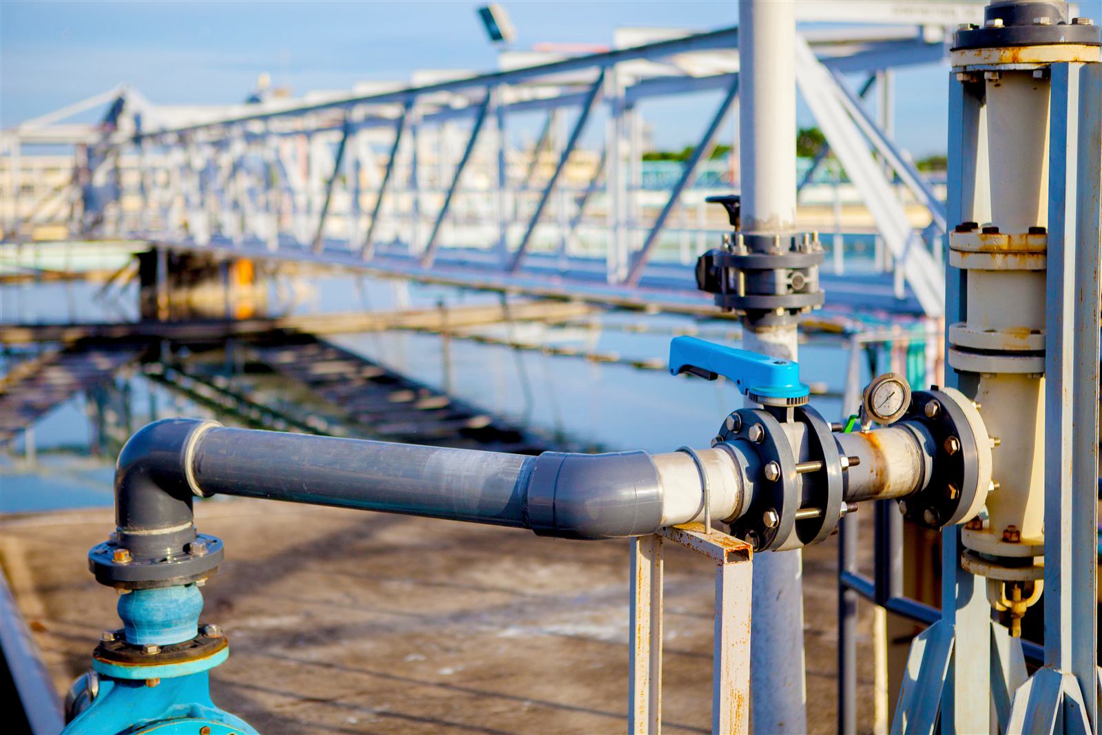 Process pipework and valves beside a treatment basin at an industrial water plant